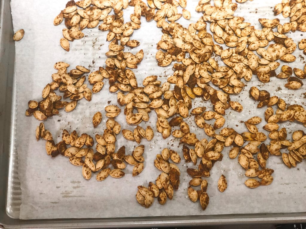 Close up of spicy roasted pumpkin seeds on sheet pan