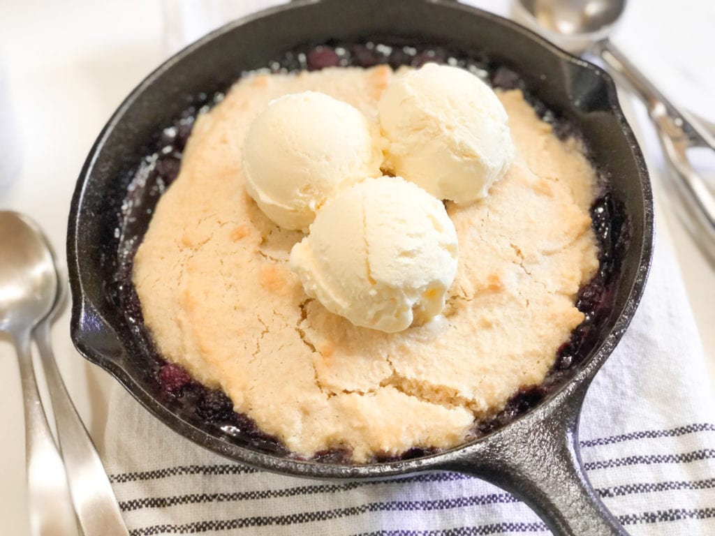Close up of blackberry cobbler in iron skillet with ice-cream 