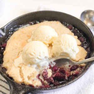 Close up of blackberry cobbler in iron skillet with ice-cream