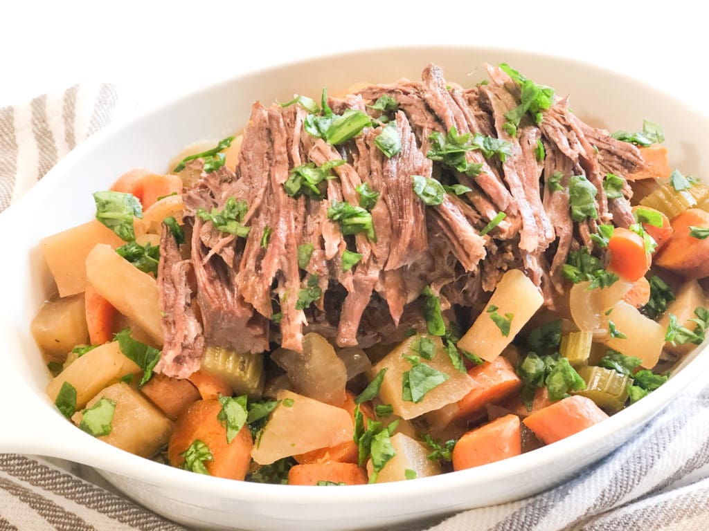 Close up and side view of pot roast in white dish