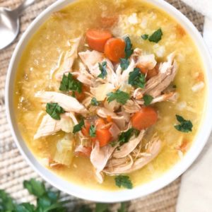 Close up of chicken-n-rice soup in white bowl.