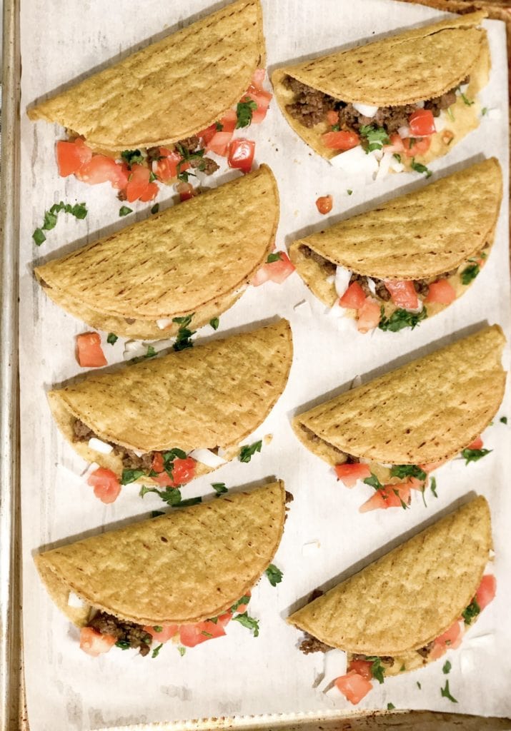 Close up of crunchy beef tacos on baking sheet