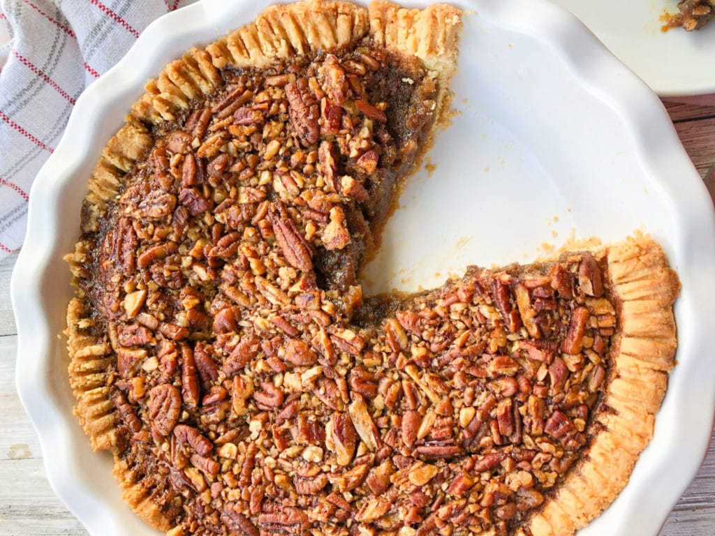Close up of healthy pecan pie with coconut cream on white plate